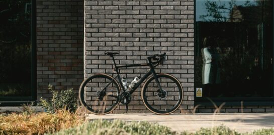 black and gray mountain bike beside brown brick wall